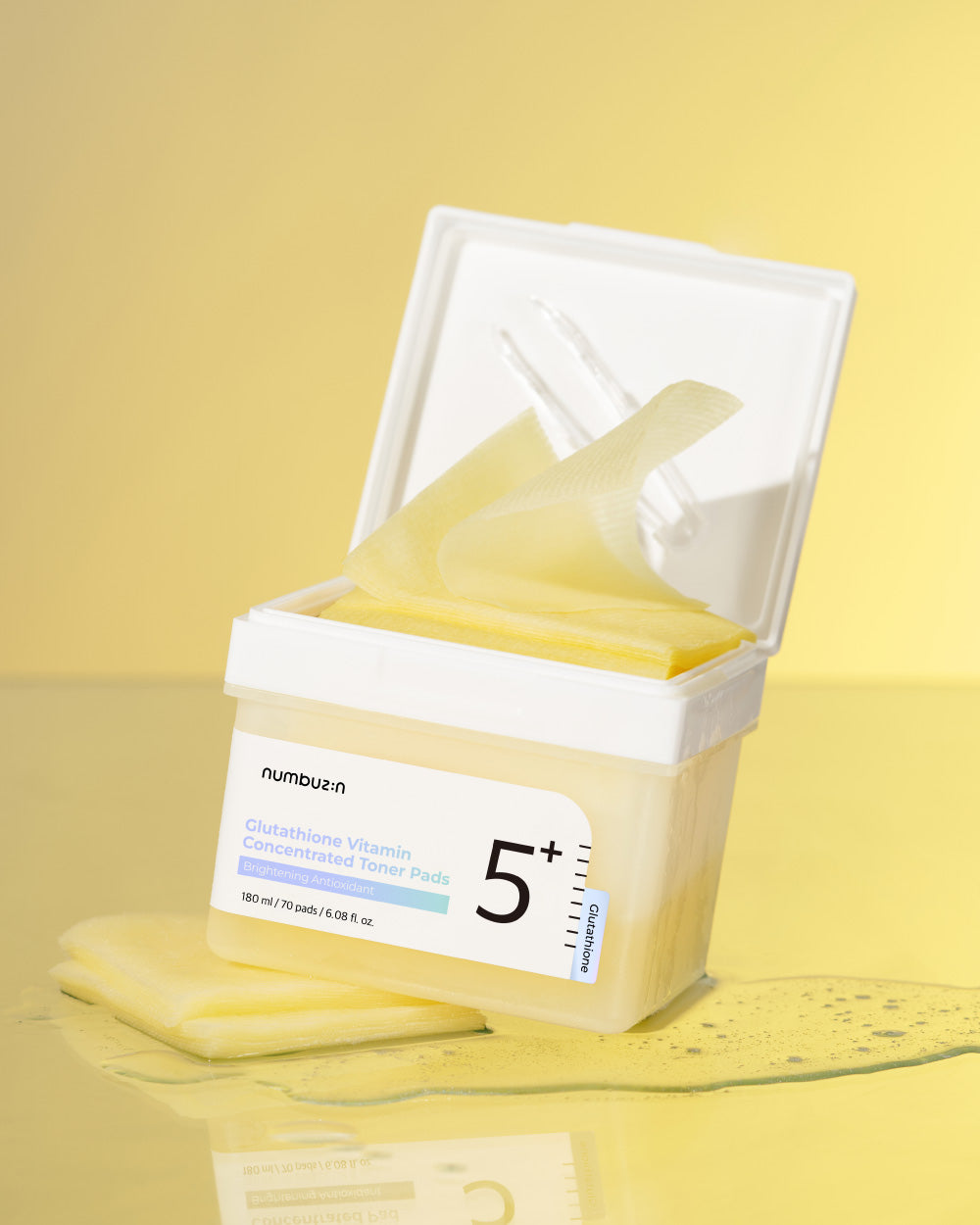 Numbuzin No.5 Vitamin Niacinamide Concentrated Toner Pads laid out on a white surface, showing their round shape and packaging.